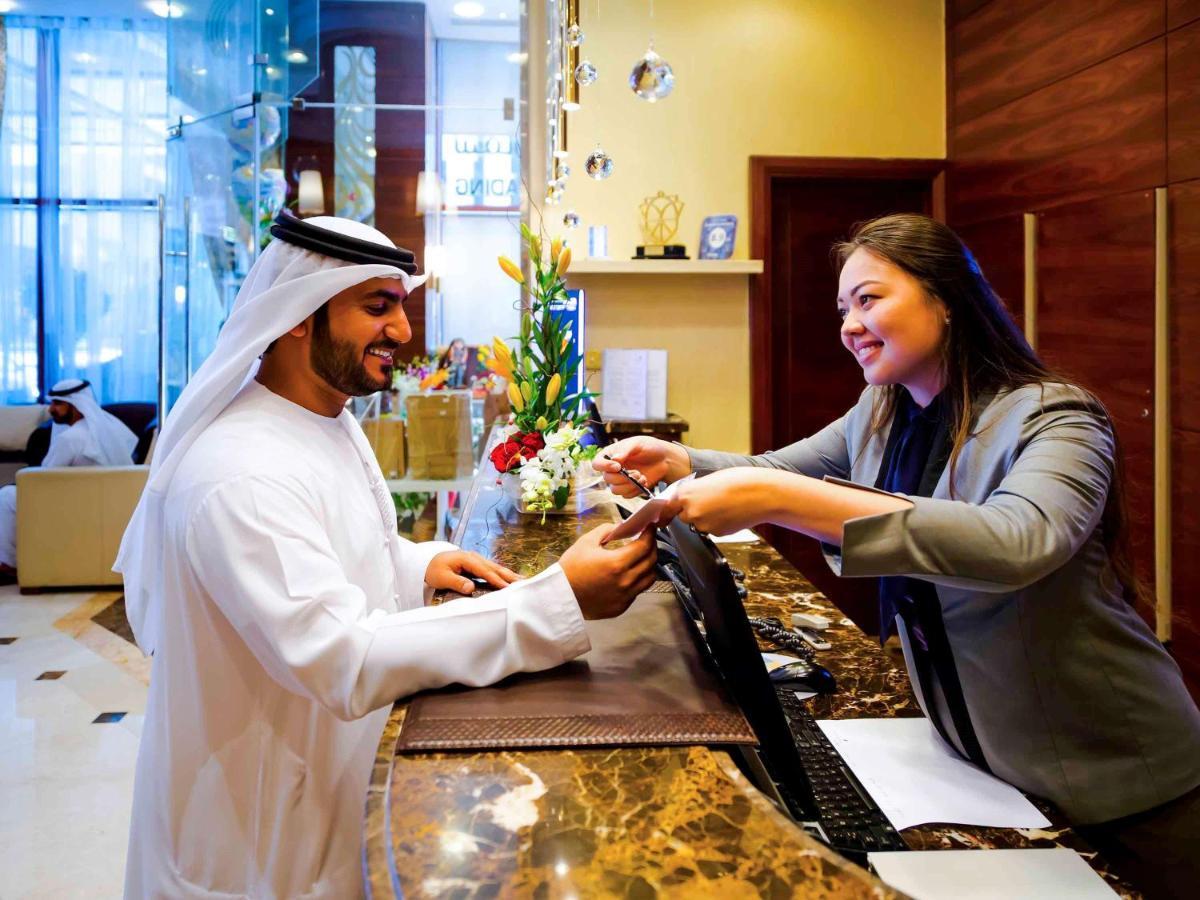 Grand Mercure Residencia Abu Dabi Exterior foto A guest checking in at a hotel